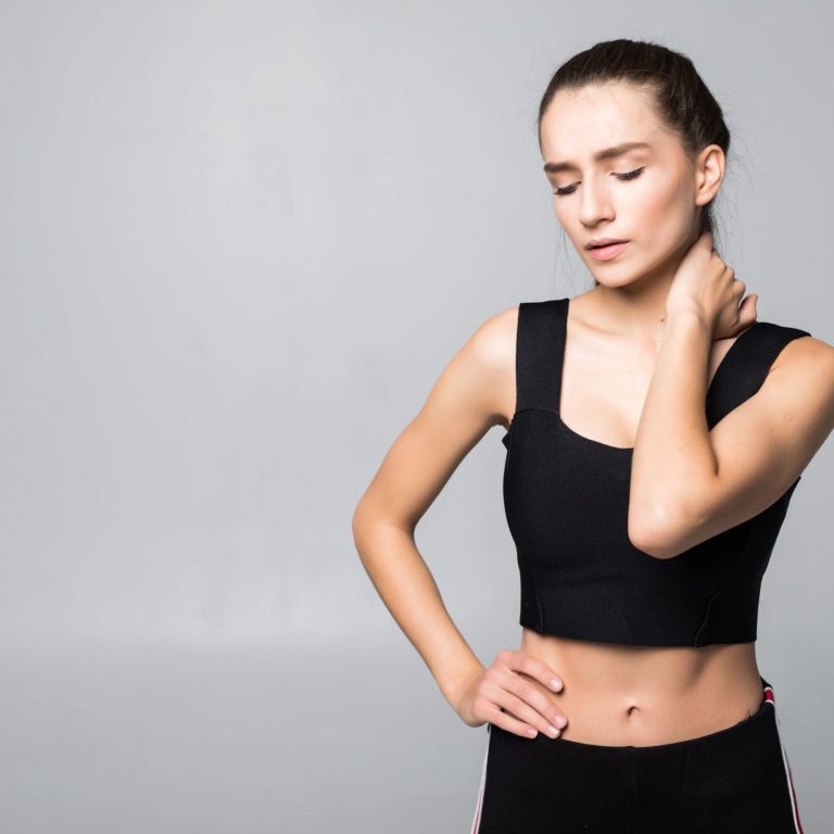 portrait-woman-fitness-outfit-experiencing-neck-shoulder-back-pain-isolated-white-wall (1)